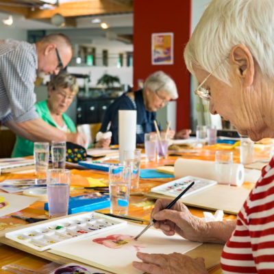 A group of people painting at a table.